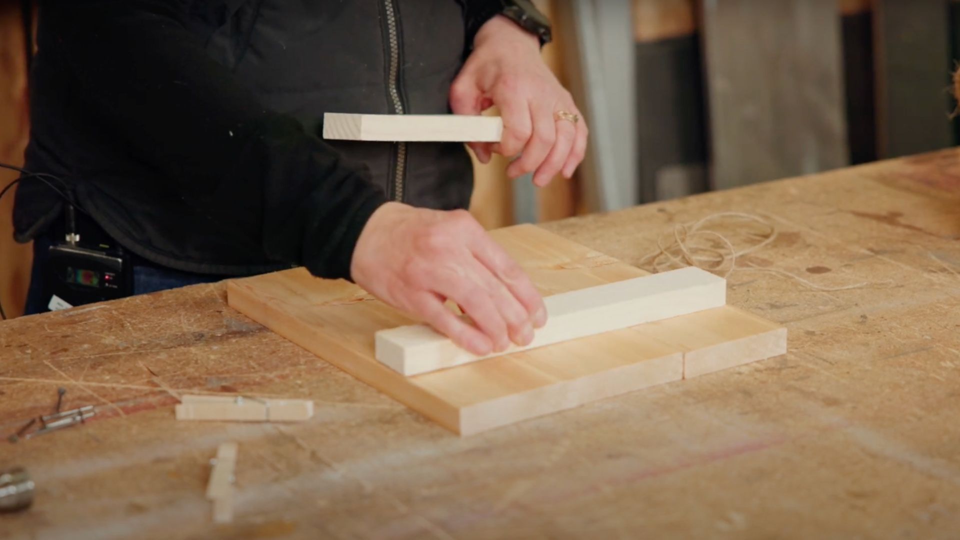 woman hands close up lining small wooden planks on three larger ones